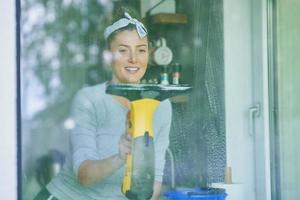 giovane donna pulizia finestra int lui cucina foto