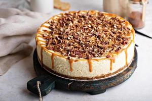 caramello pecan torta di formaggio sormontato con tritato noccioline foto