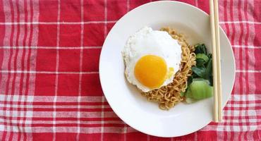 immediato tagliatelle servito con uovo fritte e mostarda verdura su piatto. immediato fritte spaghetto indomia foto