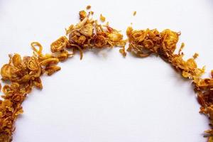 bawang goreng o mucchio di fritte indonesiano in profondità cipolla patatine fritte o scalogno con cerchio forma isolato su bianca sfondo. foto