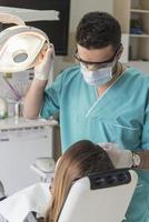 dentista curare del paziente denti Riempimento cavità. dentista Lavorando con professionale attrezzatura nel clinica. foto