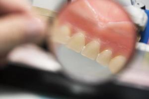 dentale protesi, dentiere, protesi opera. protesi mani mentre Lavorando su il dentiera, falso denti, un' studia e un' tavolo con dentale utensili foto