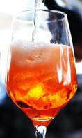 bicchiere con rinfrescante succo a il sbarra. agrume cocktail al di sopra di Ghiaccio, arancia cocktail dettagli foto