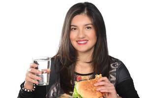 ritratto di un' bellissimo divertente giovane ragazza mangiare Hamburger foto