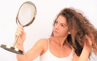 donna con disordinato Riccio capelli su bianca sfondo foto