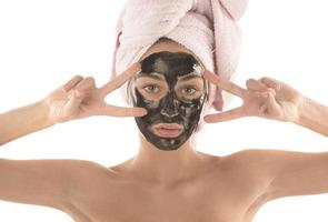 bellissimo ragazza con nero facciale cosmetico maschera. bellezza concetto. isolato foto