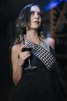 femmina alla moda modello Tenere bicchiere di vino. donna potabile vino. foto