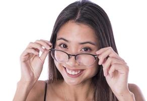 un' giovane asiatico donna mettendo su sua occhio occhiali. isolato su bianca sfondo foto