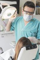 dentista curare del paziente denti Riempimento cavità. dentista Lavorando con professionale attrezzatura nel clinica. foto