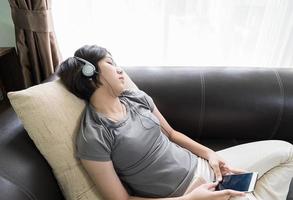 giovane asiatico donna corto capelli ascoltando musica foto