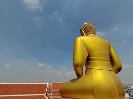 indietro Visualizza d'oro grande Budda statua Phra Budda dhammakaya il p mongkol nel wat pak nam phasi charoen tempio. luce del sole cielo e nube sfondo foto