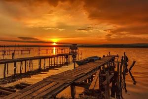 sbalorditivo tramonto a il riva del mare con di legno molo foto