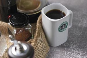 Washington, Stati Uniti d'America - settembre 30 2022 - Starbucks ceramica tazza. mettere su il grigio tavolo e caffè macchina, caffè pentola, caffè macinino, terra caffè fagioli. foto