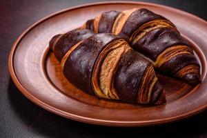 bellissimo gustoso fresco croccante brioche su un' buio calcestruzzo sfondo foto