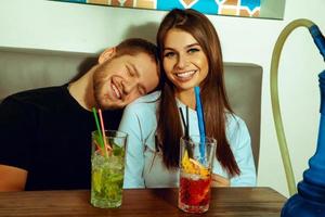 coppia rilassante a il narghilè bar con cocktail foto