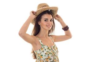 giovane allegro donna nel cannuccia cappello e sarafan con floreale modello sorridente su telecamera isolato su bianca sfondo foto