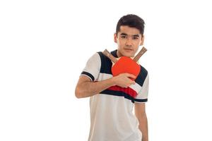 giovane grave brunetta uomo giocando ping-pong isolato su bianca sfondo nel studio foto