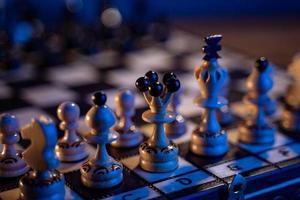 scacchi tavola con scacchi pezzi su blu sfondo. concetto di attività commerciale idee e concorrenza e strategia idee. bianca re e Regina vicino su. foto