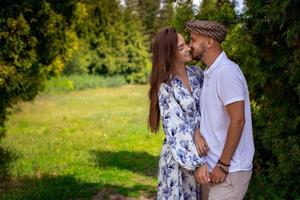 coppia nel amore abbracci e sorrisi Tenere mani a il verde giardino foto