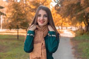 bellissimo ragazza sorridente e Tenere un' sciarpa con il tuo mani foto