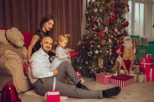 orizzontale foto di contento famiglia con figlia celebrare nuovo anno e Natale insieme a casa