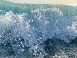 onde, spruzzi di acqua su il spiaggia a il mare su vacanza nel un' turista caldo orientale tropicale nazione meridionale Paradiso ricorrere su vacanza. il sfondo foto