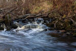 un' piccolo roccioso foresta fiume nel autunno foto