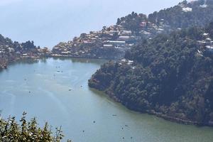 vista completa del lago naini durante la sera vicino alla strada del centro commerciale a nainital, uttarakhand, india, bellissima vista del lago nainital con montagne e cielo blu foto