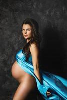 bella incinta donna con un' bellissimo blu volante raso tessuto foto