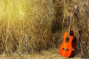 acustico chitarra e mucchi di fieno nel il villaggio foto