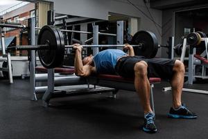 muscolare uomo durante allenarsi nel il Palestra foto