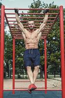 muscolare uomo fare pull-up su orizzontale bar foto