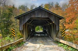 grist mulino coperto ponte nel Cambridge, Vermont durante autunno fogliame. foto
