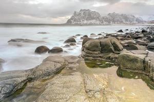 onde fluente al di sopra di utakleiv spiaggia, lofoten isole, Norvegia nel il inverno. foto