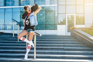 elegante ragazza con un' skateboard su il strada foto