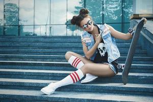 elegante ragazza con un' skateboard su il strada foto