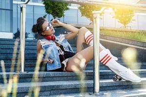 elegante ragazza con un' skateboard su il strada foto