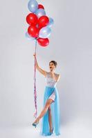 donna indossare bellissimo vestito con un' lotto di colorato palloncini foto