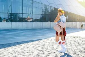 elegante adolescenziale ragazza con zaino su il strada foto