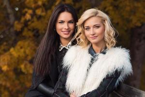 ritratto di Due bellissimo ragazze amici nel autunno parco foto
