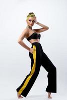 donna con giallo capelli indossare nero pantaloni con giallo strisce foto