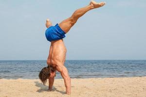 muscolare uomo durante il suo allenarsi su il spiaggia foto