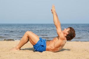 muscolare uomo durante il suo allenarsi su il spiaggia foto