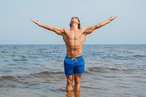 muscolare uomo durante il suo allenarsi su il spiaggia foto