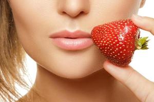 vicino su di femmina labbra con un' fragola foto