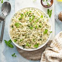 cavolfiore riso con erbe aromatiche e Limone succo nel un' bianca ciotola foto