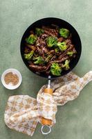 Manzo e broccoli agitare friggere nel un' piccolo wok foto