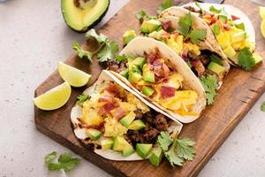 prima colazione tacos con salsiccia, uova, Bacon e avocado foto