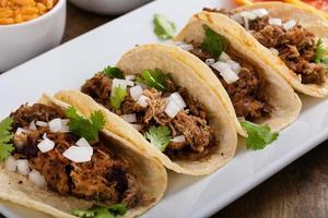 Maiale Carnitas tacos su Mais tortillas con riso e fagioli foto