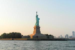 statua di libertà a tramonto a partire dal nuovo York città foto